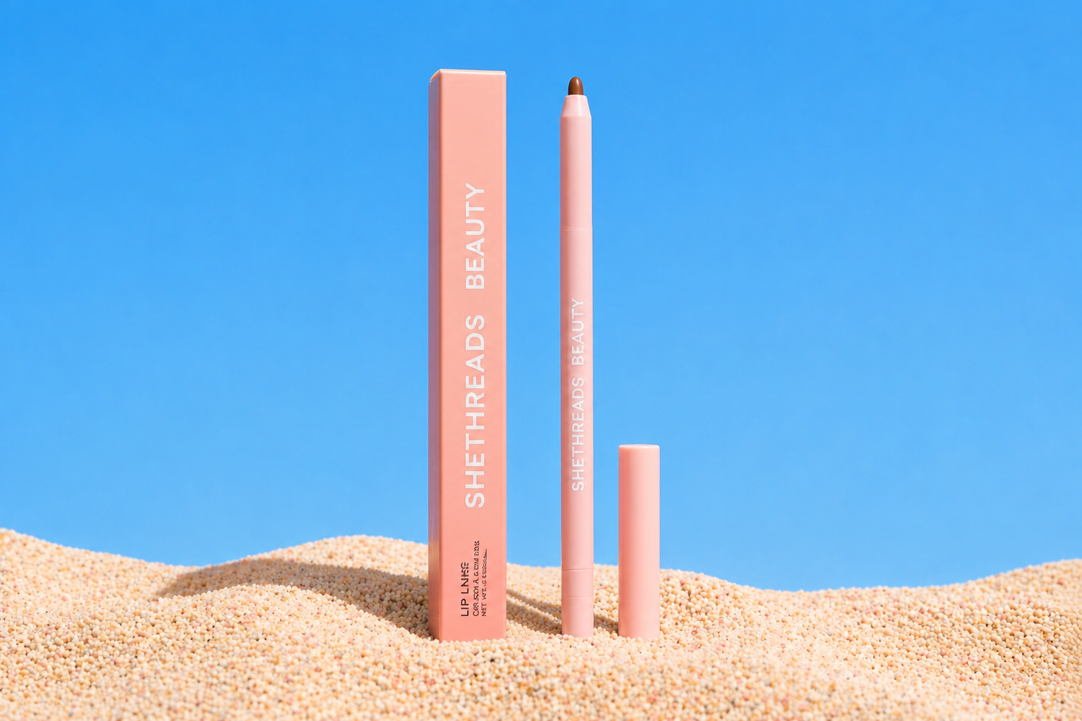 Shethreads Beauty lip liner in sand against a blue sky